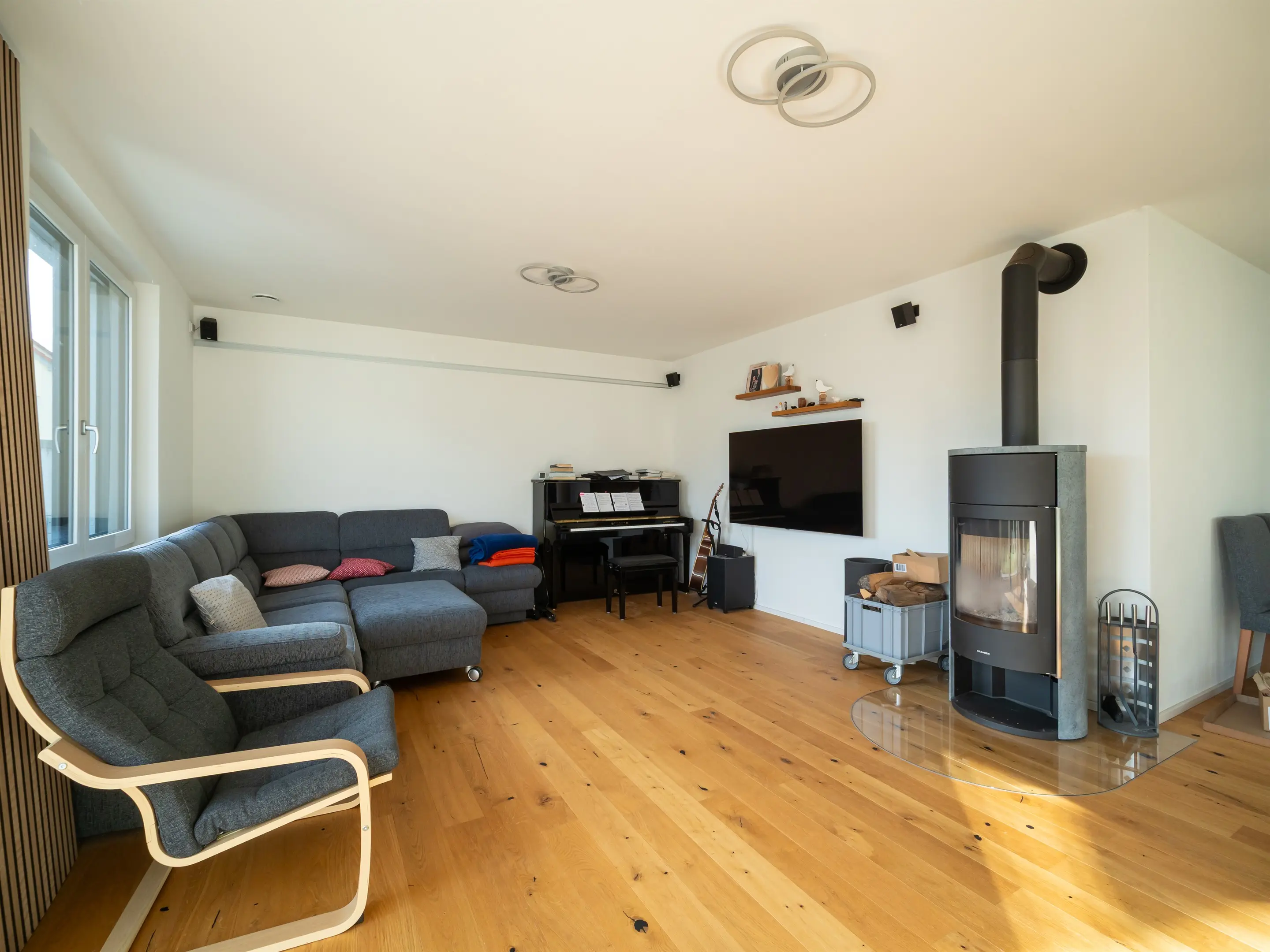Wohnraum mit Kaminofen und Holzlamellen