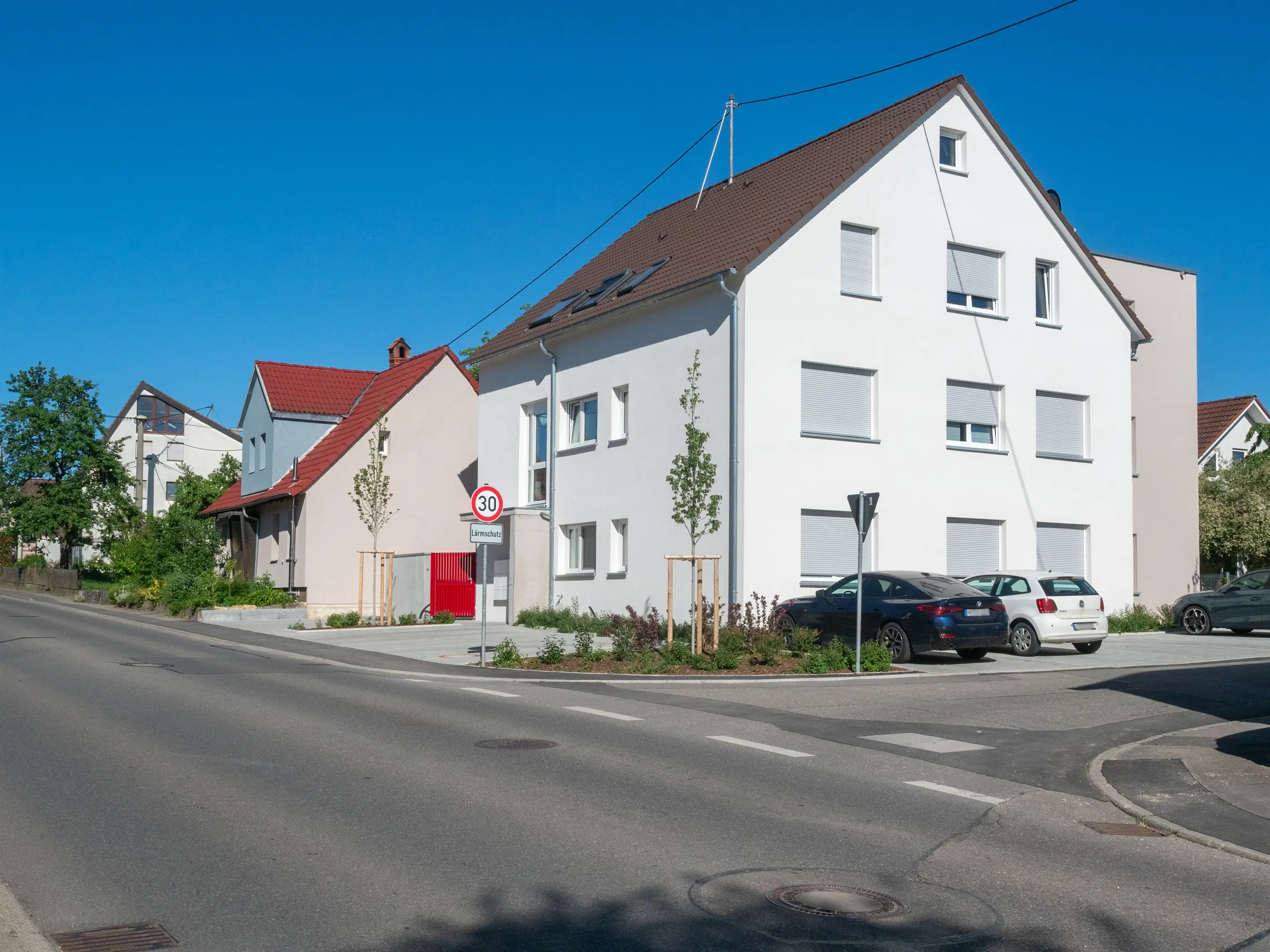 Straßenansicht über Eck, Giebelseite des Mehrfamilienhauses an der Kreuzung